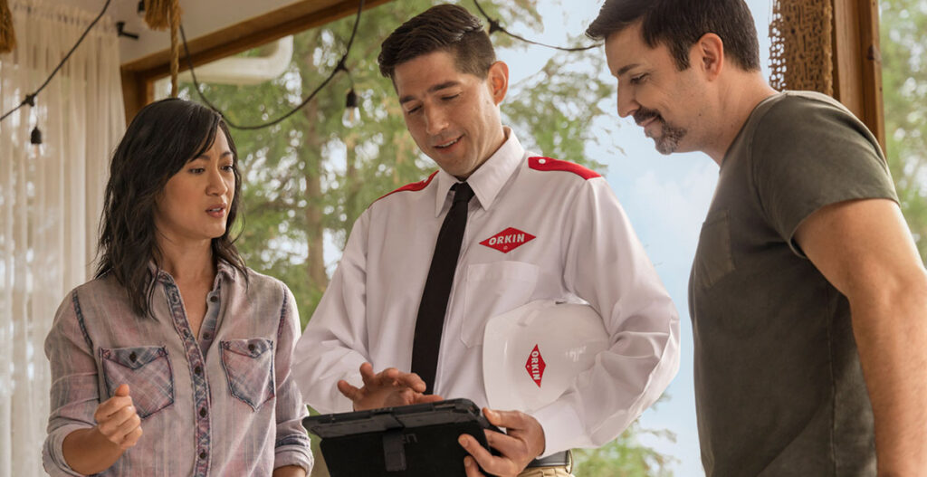 photo of an Orkin technician talking to homeowners