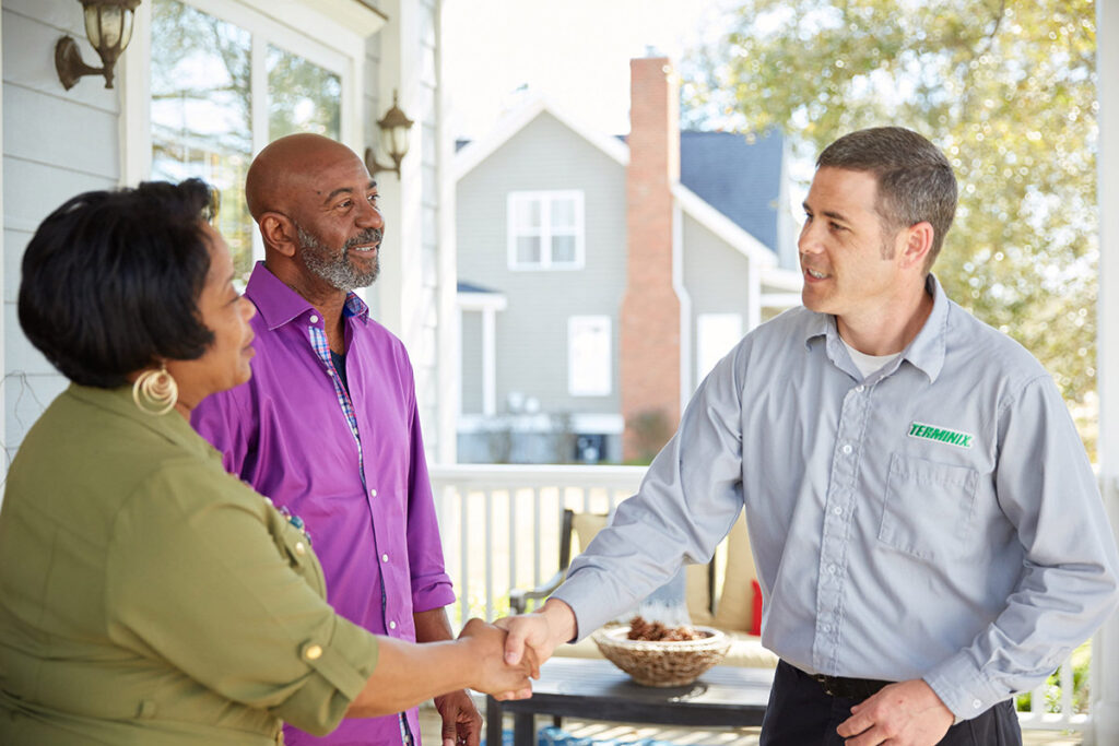 photo of a Terminix technician talking to homeowners